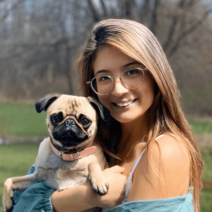 Woman outside holding her dog.