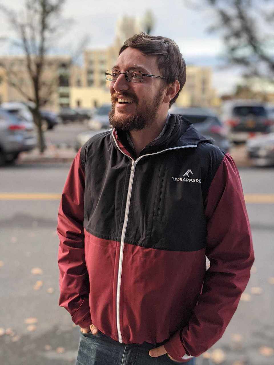 Greg Mahnken, Associate Product Manager, standing in red and black coat.