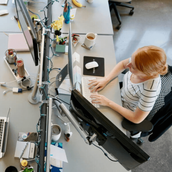 Woman sits working at her desk.