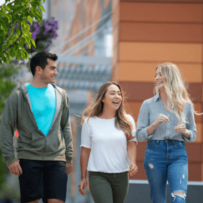 Three people walking and chatting outside.