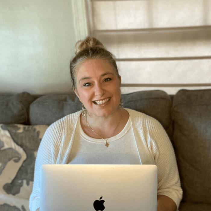 Jenni Thornton sitting on a couch with her laptop.