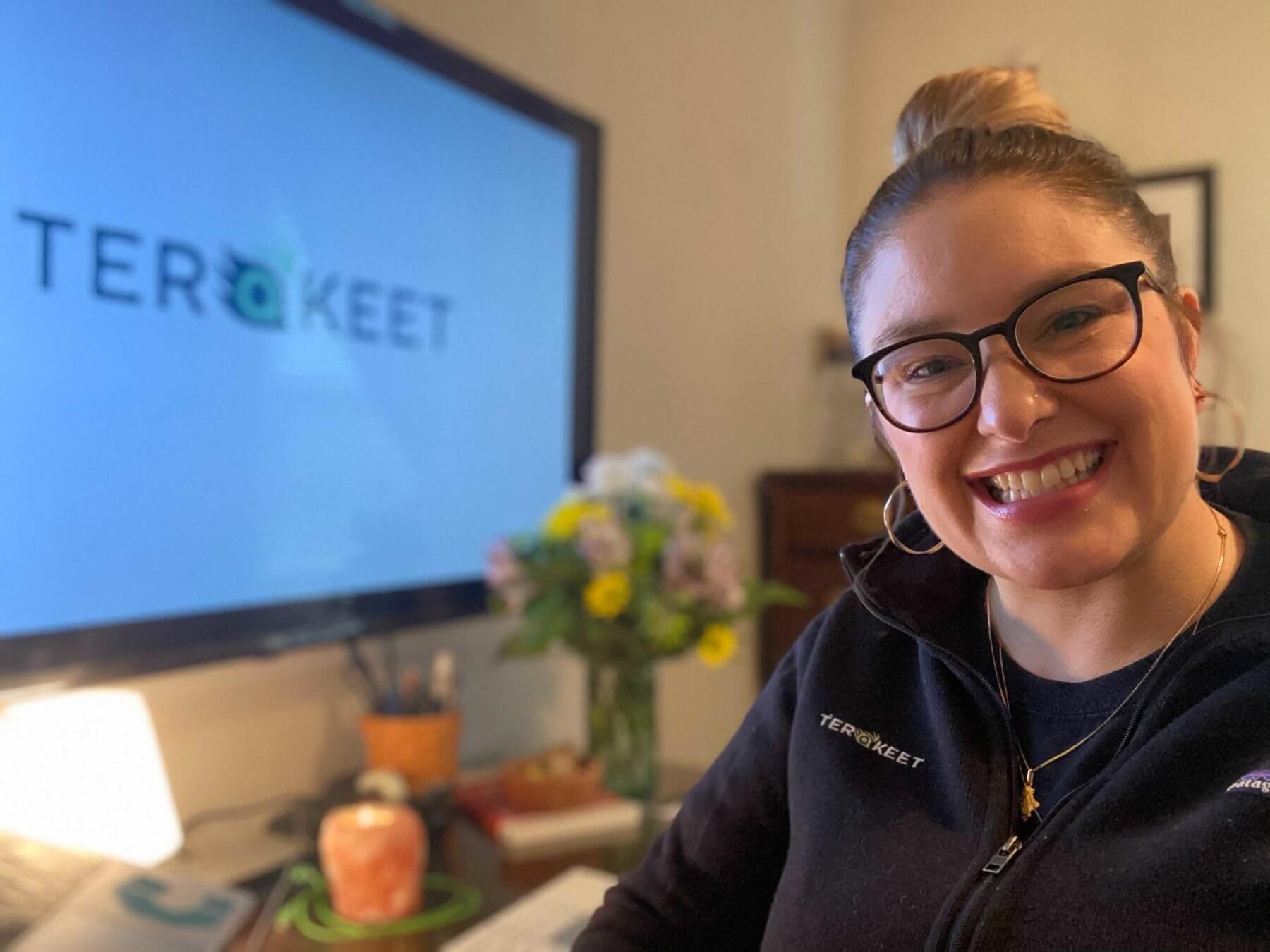 Jenni thornton 2020 marc murray award winner, sitting in front of computer with terakeet logo