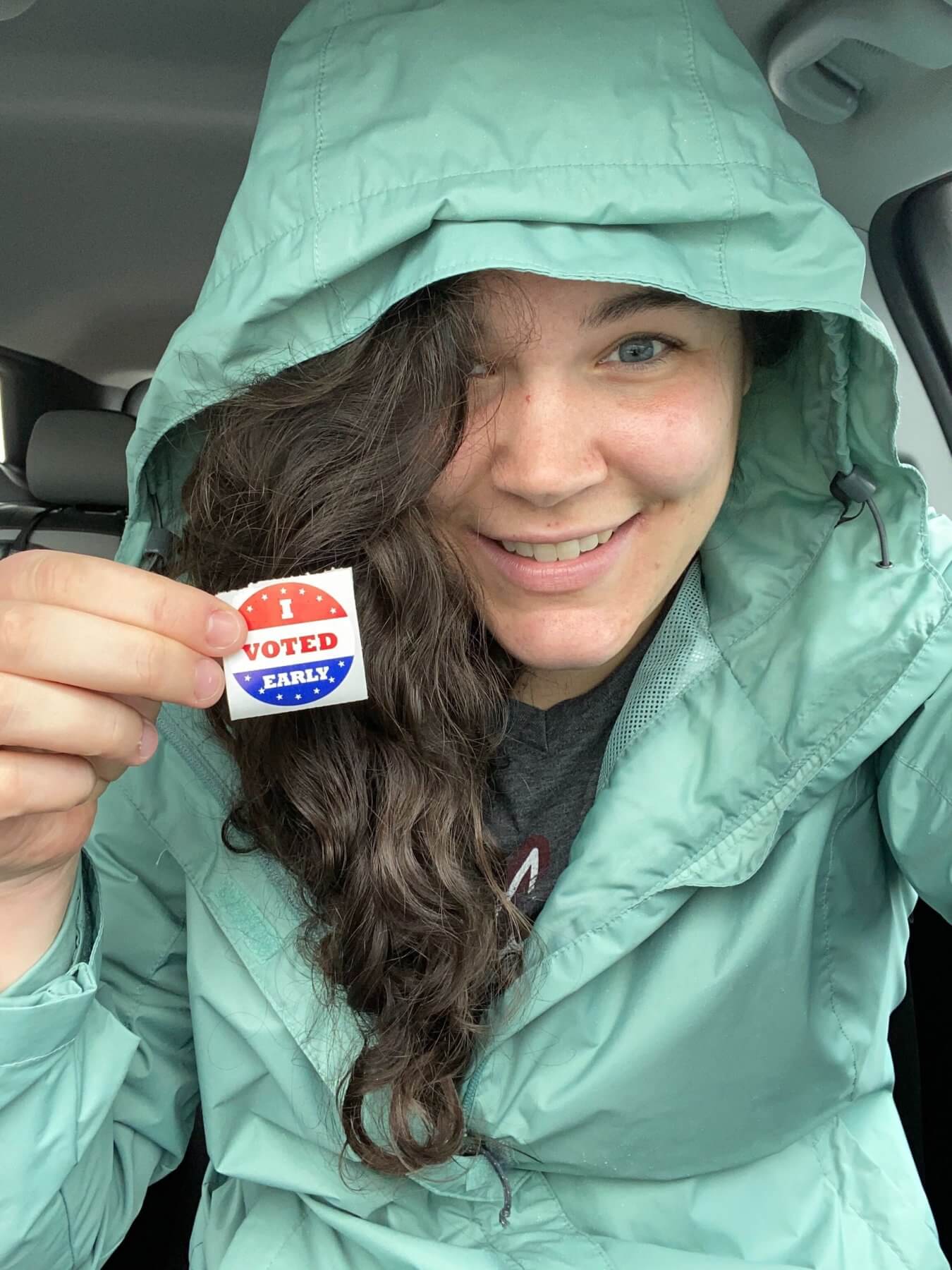 Anneliese Harrison holds up her "I voted" sticker
