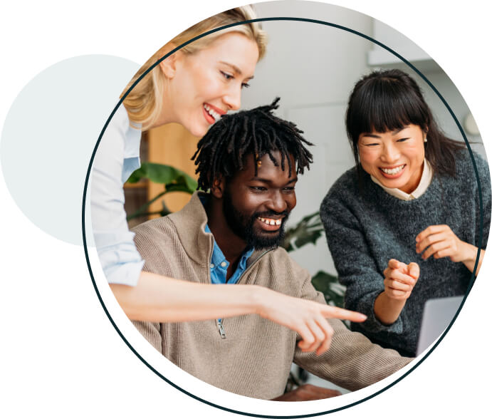 A diverse group of three coworkers exitedly looking at a computer.