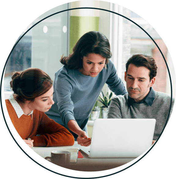 Three coworkers looking intently at a laptop.