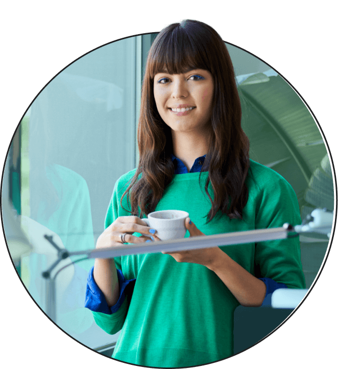 A woman drinking coffee in a home office.