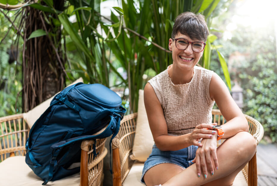 A woman with a backpack sitting in a chair.