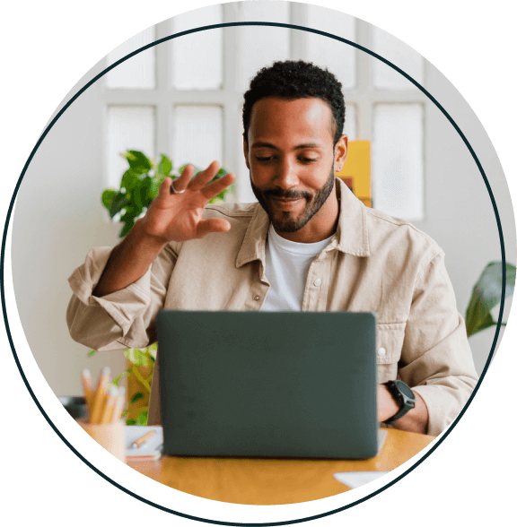 A man on a zoom call sitting in front of his laptop.