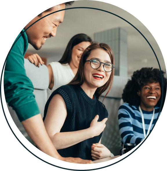 A group of four people laughing at work.