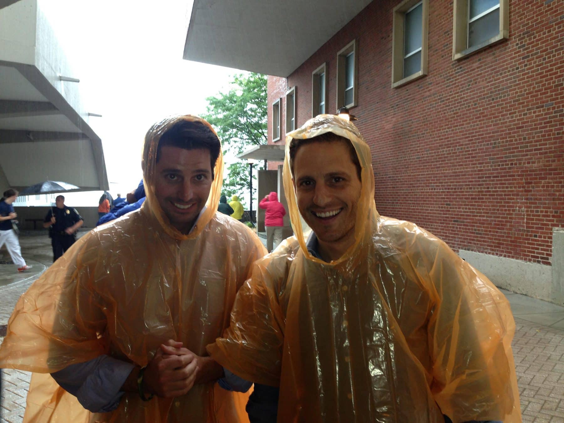 Two men in ponchos laugh
