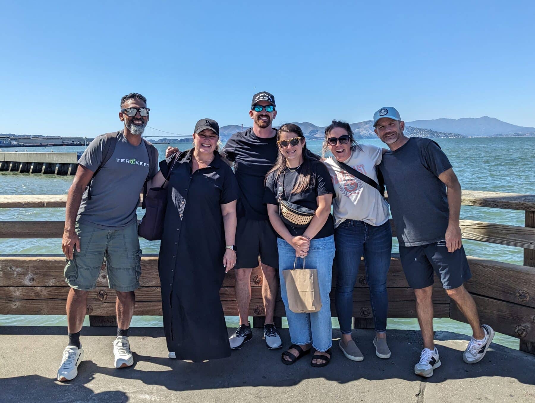 Six people pose for a photo near the Golden Gate Bridge