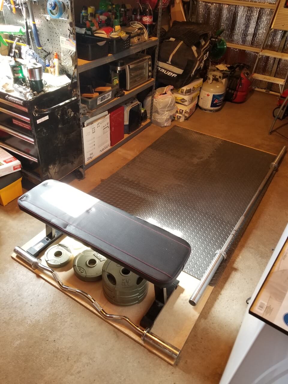 workout bench, weights, bars, inside a garage