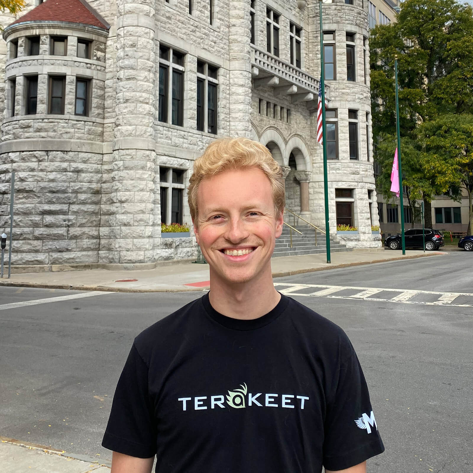 tristan amond wearing terakeet shirt standing in front of syracuse city hall